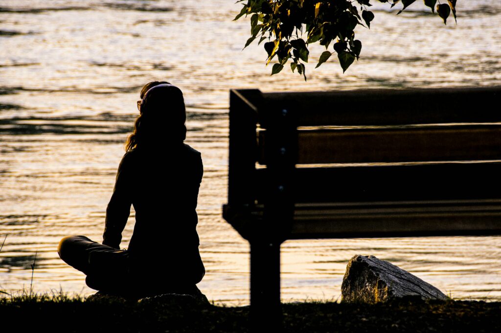 Women meditating near a bench